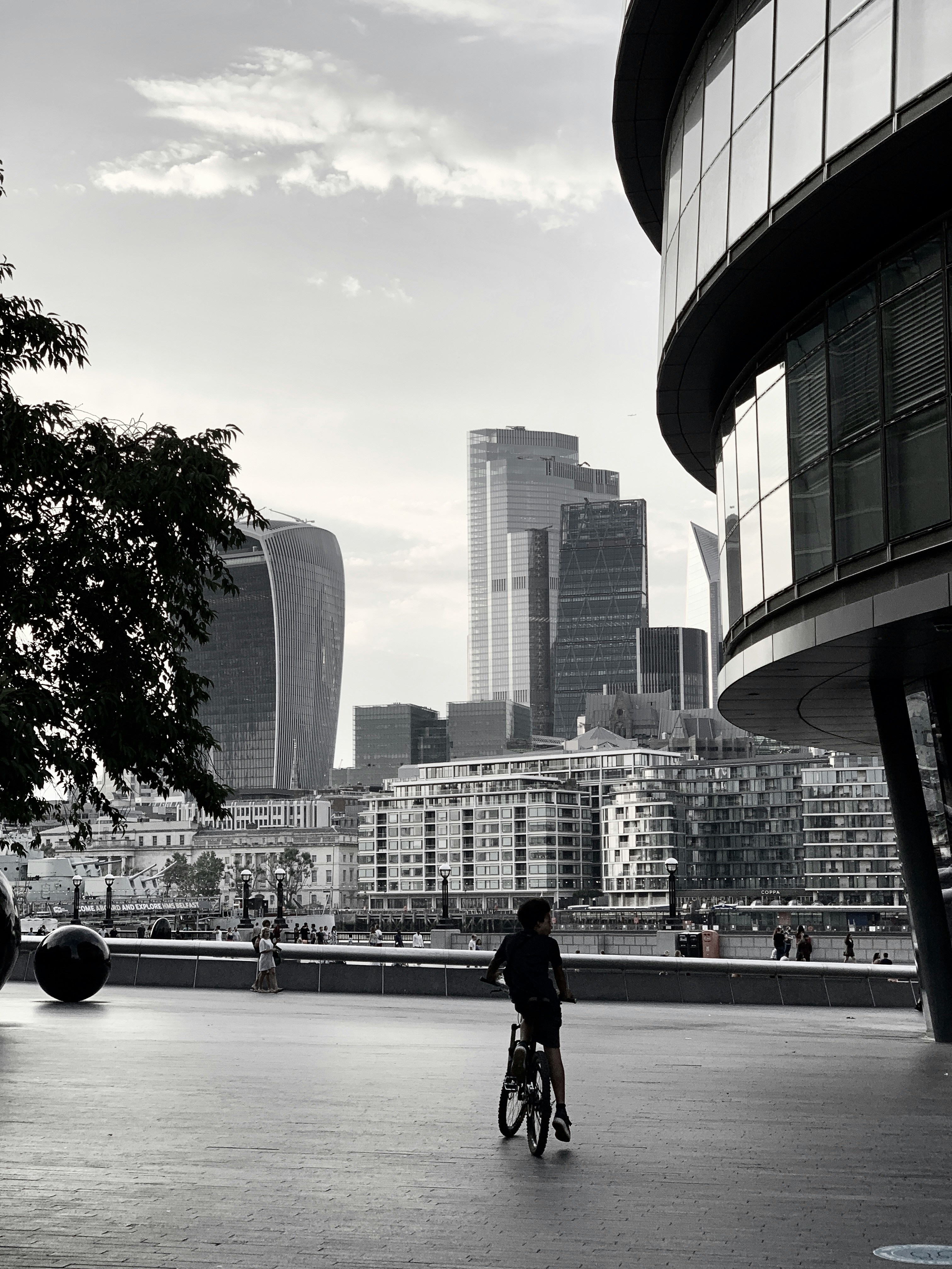 Photgraph of a person stopped on their bike by London City Hall.